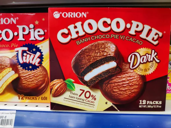 Saigon / Vietnam - July 01 2019: Boxed cakes and biscuits on supermarket shelves. Assorted boxes of branded cake flours. A grocery store shelf with baking: Orion Choco-Pie, Solite, Goute, LU, Custas