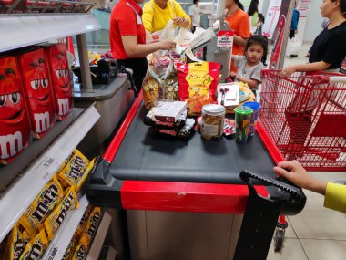 Kadınlar ve küçük kız süpermarkette kasada.