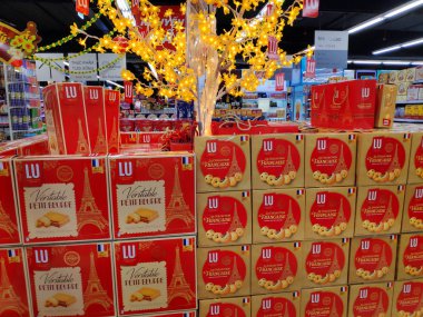 Süpermarket raflarında uygun fiyata çeşitli kurabiye ve bisküvi markaları. Satmak için kutu şeklinde kek sergisi. Market rafı ve fırınlanmış pasta..