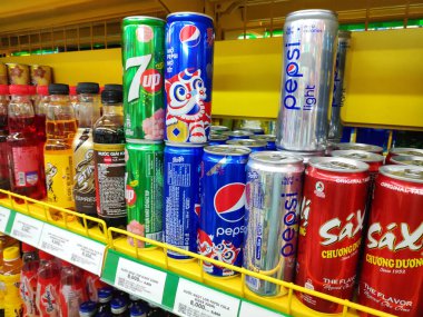 Karbonatlı içecekler tatlı su, içecek çayı krema ve şekerle karıştırılmış kahve suyu süpermarketteki raflarda sergilenen çeşitli içki şişeleri ve kutular..