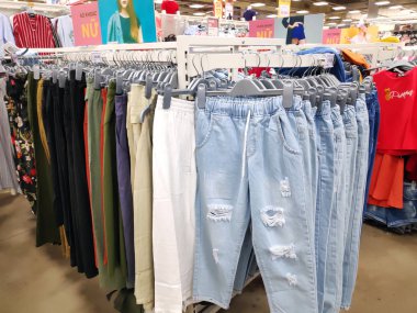 Süpermarkette asılı bir sürü kot pantolon. Raf alışverişinde bir yığın kot pantolon. Bir giyim mağazasının rafına asılmış mavi kot pantolonlar..