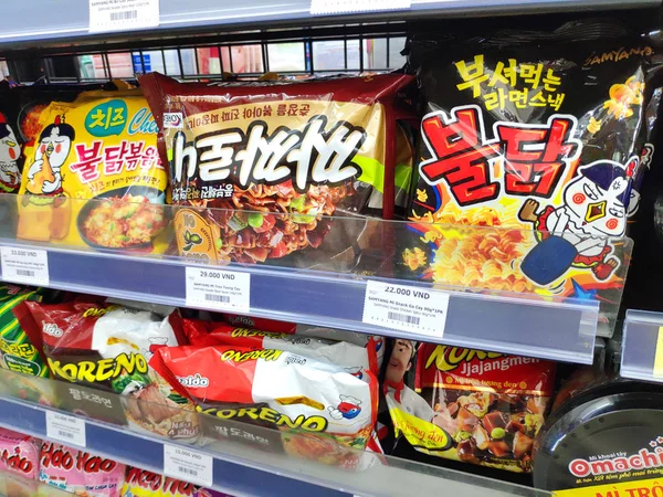 スーパーマーケットの棚に展示されているインスタントラーメンの様々なブランド 韓国のスーパースパイシーな麺個々のパックとカップ食料品店で不健康なファーストフードパッケージ — ストック写真