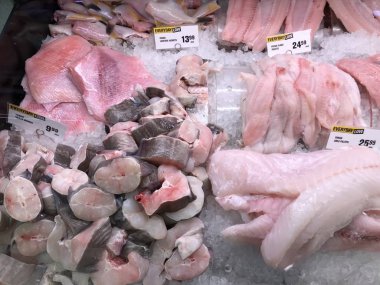 Süpermarketteki buz küpündeki lezzetli çiğ ahtapot ve mürekkep balığı taze deniz ürünleri dokunaçları sağlıklı besleyici yiyecekler yakalar. 