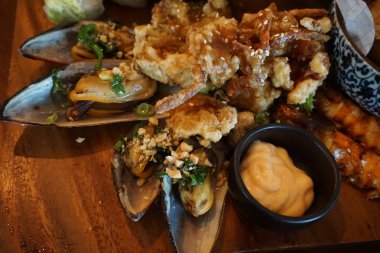 Fıstık ezmeli ızgara deniz tarağı ve kıyılmış fıstık ezmesi soğan, balık sosu sarımsaklı biber sosu Asya mutfağı geleneksel Vietnam yemekleri deniz ürünleri sokak yemekleri. 