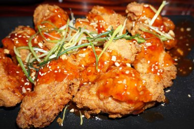 Lezzetli, kıtır kıtır, baharatlı baharatlı tavuk ballı soya soslu fıstık ezmesi ve yanında tatlı biber sosu Kore mutfağı. 