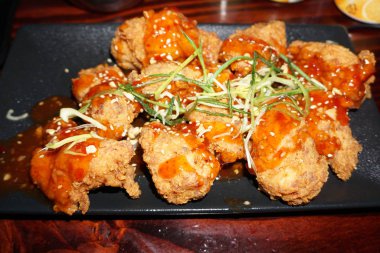 Lezzetli, kıtır kıtır, baharatlı baharatlı tavuk ballı soya soslu fıstık ezmesi ve yanında tatlı biber sosu Kore mutfağı. 