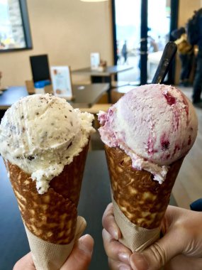 Süper büyük konide lezzetli hindistan cevizli çikolata tadı yaz mevsiminde Patagonya Queenstown Yeni Zelanda 'da göl ve dağ arka planında tatlı tatlı tatlı tatlı yemek zorundadır.