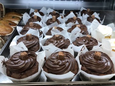 Çikolata parçacıklı muzlu kek çikolatalı kek koyu badem badem yaban mersinli tatlı kahvaltıda taze pişmiş süpermarket rafı renkli kremalı pasta. 