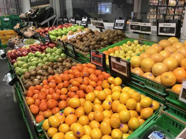 Saigon / Vietnam - 01 Aralık 2019: Süpermarkette raflarda taze sağlıklı meyveler. İçinde farklı meyve çeşitleri olan sepetler kırmızı ve yeşil elmalar, olgun mango. Diyet için günlük olarak organik gıdalar.