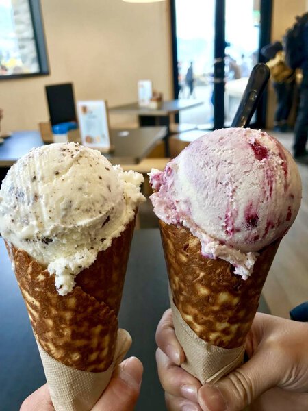 Вкусное мороженое вкусом кокосового шоколада в супер большой конус должны есть пищу сладкий десерт в летнее время Патагония Куинстаун Новая Зеландия с озером и горным фоном
