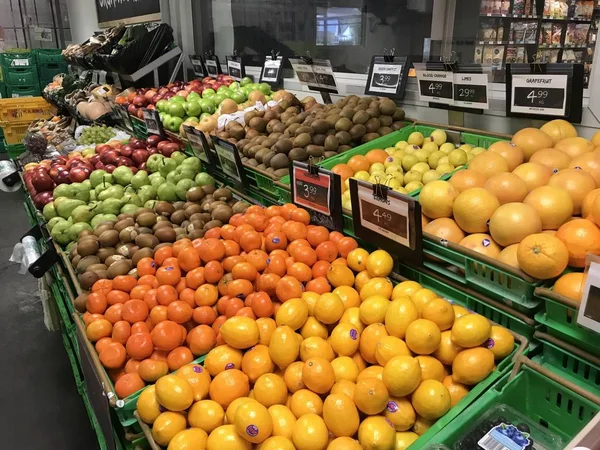 Saigon / Vietnam - 01 Aralık 2019: Süpermarkette raflarda taze sağlıklı meyveler. İçinde farklı meyve çeşitleri olan sepetler kırmızı ve yeşil elmalar, olgun mango. Diyet için günlük olarak organik gıdalar.