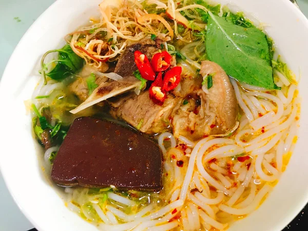 胡テウナムバン豚肉の牛肉とベトナム麺スープ伝統的な食品牛肉の鶏のスープハーブチリソース新鮮なチリソース春を振りかける — ストック写真