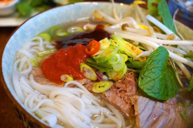 Pho Bo Vietnamlı şehriye çorbası, domuz eti, kızarmış soğan ve sebze, geleneksel et, tavuk, et, sebze, acı biber sosu taze taze soğan. 