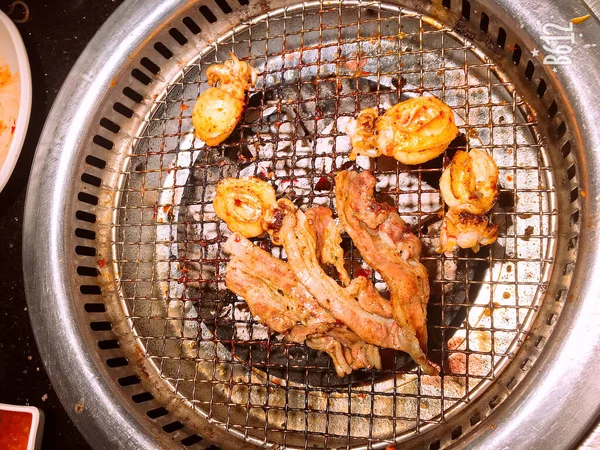 スパイシーなタコのシーフードと肉を野菜とバーベキュービュッフェで焼きます ホワイトプレートのBbqシーフードに唐辛子ハーブニンジンの花と串焼きにおいしい焼きエビ スパイシーなタコの魚介類と肉のバーベキュービュッフェで野菜と誕生日ケーキ — ストック写真