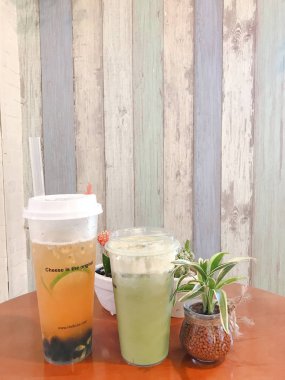 Bardakta buzlu kahve, ahşap masada buz küpleri.