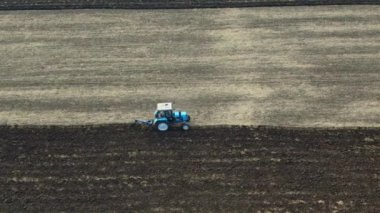 Mevsimin sonunda tarlayı süren küçük bir traktör, ekime hazırlanıyor, sonbaharın sonlarında, kırsal kesimde, insansız hava aracından ateş ediyor..