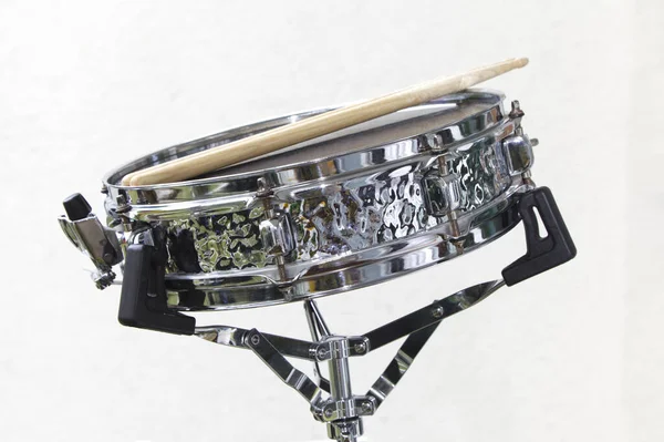 Snare drum with drumsticks made of hand hammered steel shell isolated on white
