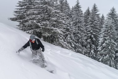 Pudra kar tepesinden snowboardcu geliyor. Dağ sporu snowboard 'u. Kış Karpatları