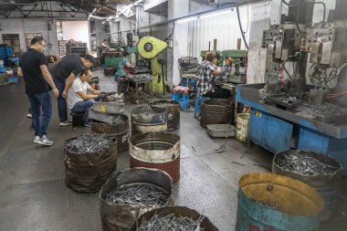 Cixi, China - 05 Sep 2019: Metallurgical plant of metal tools. Workers in the process. clipart