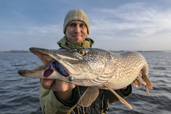 Gäddfiske. Glad fiskare som håller stor fisk på båten — Stockfoto