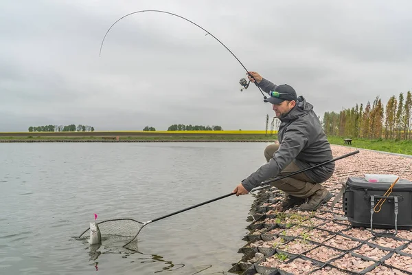 Alabalık avı. Harekete geçen oltayla oynayan balıkçı — Stok fotoğraf