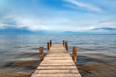 Göl kenarındaki ahşap iskele manzaralı. Sudaki küçük köprü