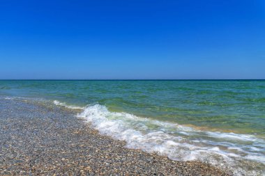 Deniz sahili, kum, mavi gökyüzü. Deniz gevşeme manzarası ve yaz tatili konsept tasarımı