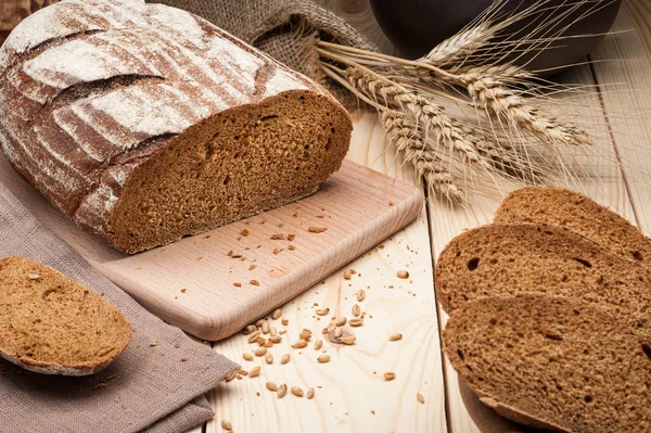 Na drewnianym stole w plasterkach chleba — Zdjęcie stockowe