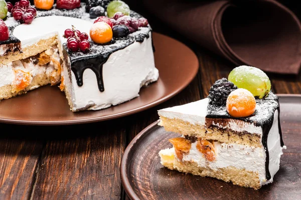 chocolate berry cake slice on plate over brown wooden background