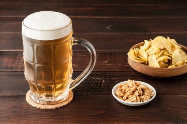 soğuk köpüklü lager bira ve cips plaka üzerinde ahşap bardak