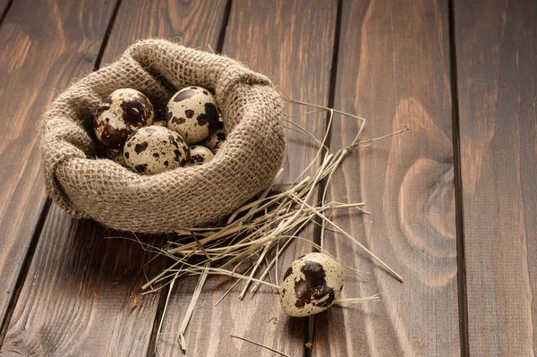 çuvala koyu ahşap arka plan üzerinde bıldırcın yumurtası