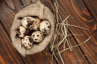 çuvala eski ahşap arka plan üzerinde bıldırcın yumurtası üzerinde Üstten Görünüm