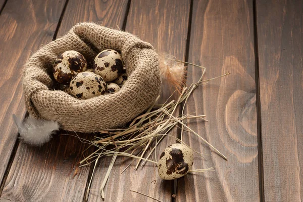 çuvala koyu ahşap arka plan üzerinde bıldırcın yumurtası