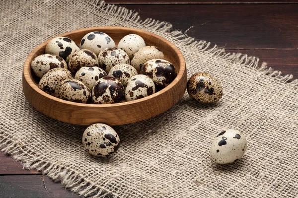 Перепелині яйця в дерев'яній тарілці на темному старому дерев'яному фоні — стокове фото