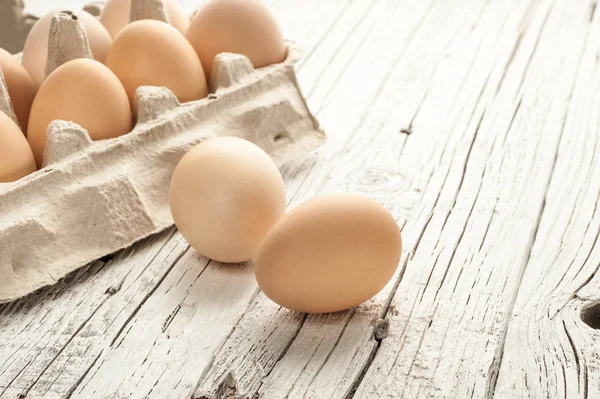 tavuk yumurtası Beyaz ahşap zemin üzerine karton kutu içinde