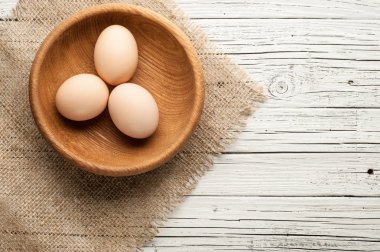 tavuk yumurtası Beyaz ahşap zemin üzerinde ahşap plaka