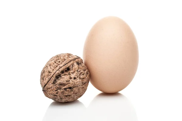 Slepičí vejce a matice postavení izolovaných na bílém pozadí — Stock fotografie