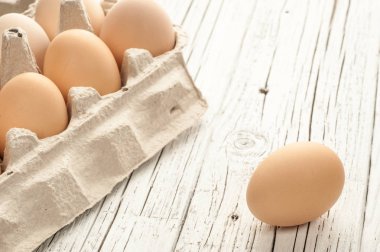 tavuk yumurtası Beyaz ahşap zemin üzerine karton kutu içinde