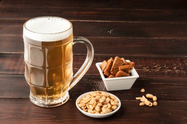 bardak soğuk köpüklü lager bira ve fıstık plaka üzerinde ahşap tabl