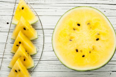 Beyaz ahşap zemin üzerine sarı karpuz dilimleri görünümü top