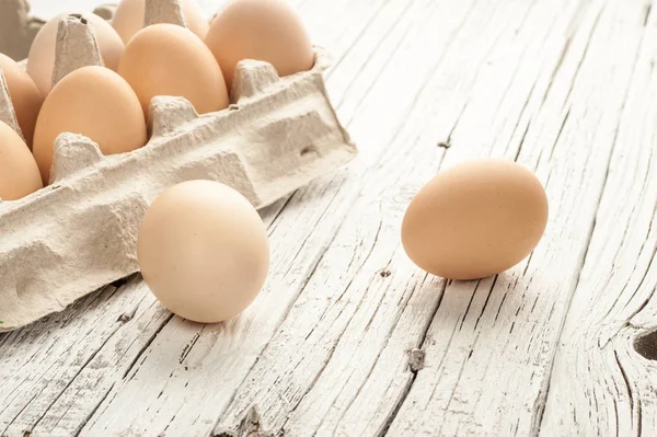 tavuk yumurtası Beyaz ahşap zemin üzerine karton kutu içinde
