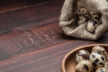 çuvala eski ahşap arka plan üzerinde bıldırcın yumurtası