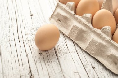 tavuk yumurtası Beyaz ahşap zemin üzerine karton kutu içinde