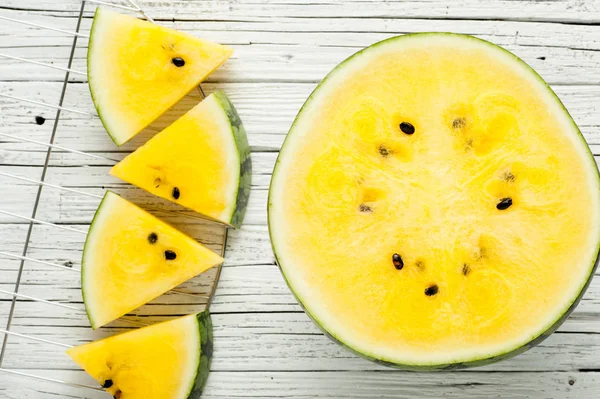 Beyaz ahşap zemin üzerine sarı karpuz dilimleri görünümü top