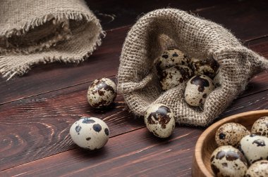 çuvala eski ahşap arka plan üzerinde bıldırcın yumurtası