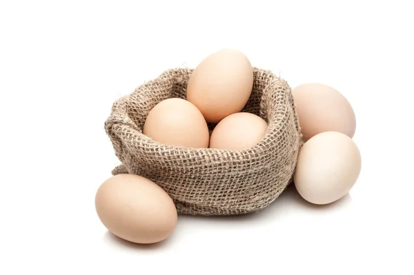 Ovos de galinha em saco de serapilheira isolado no fundo branco — Fotografia de Stock