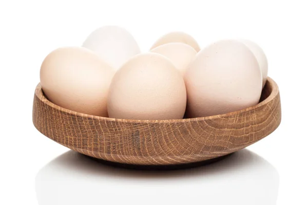 Chicken eggs in a wooden plate isolated on white background — Stock Photo, Image