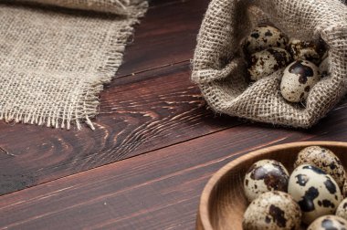 çuvala eski ahşap arka plan üzerinde bıldırcın yumurtası