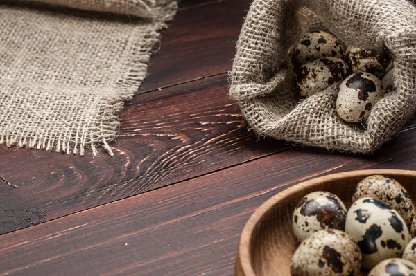 çuvala eski ahşap arka plan üzerinde bıldırcın yumurtası