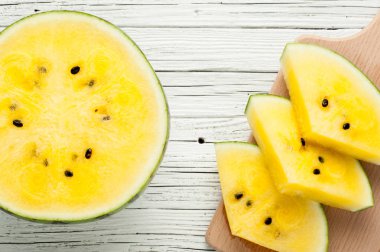 Beyaz ahşap zemin üzerine sarı karpuz dilimleri görünümü top